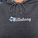 Dark grey hoodie with Billabong spellout on a plain background
