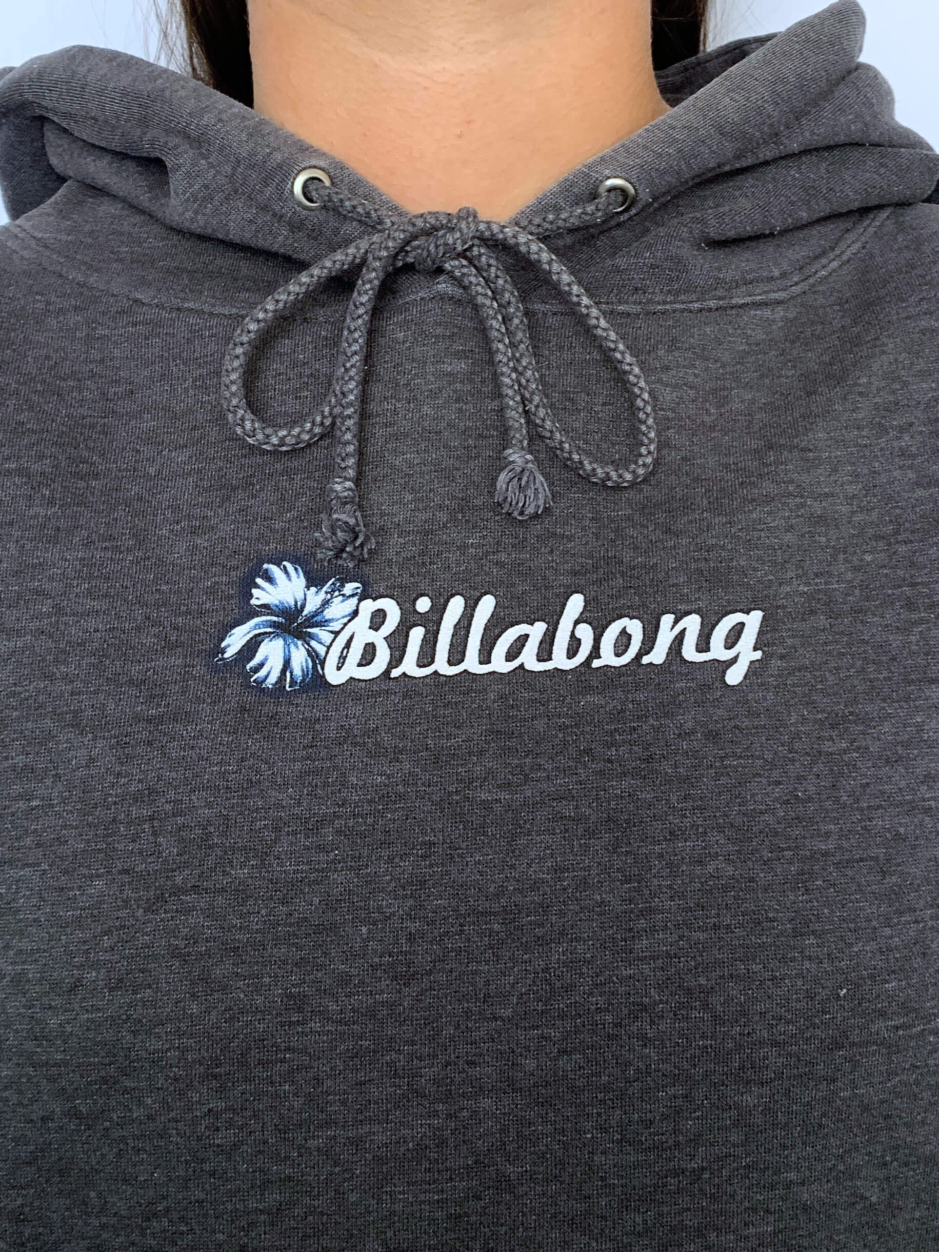 Dark grey hoodie with Billabong spellout on a plain background