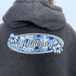 Grey hoodie with Billabong logo on the back against a white background
